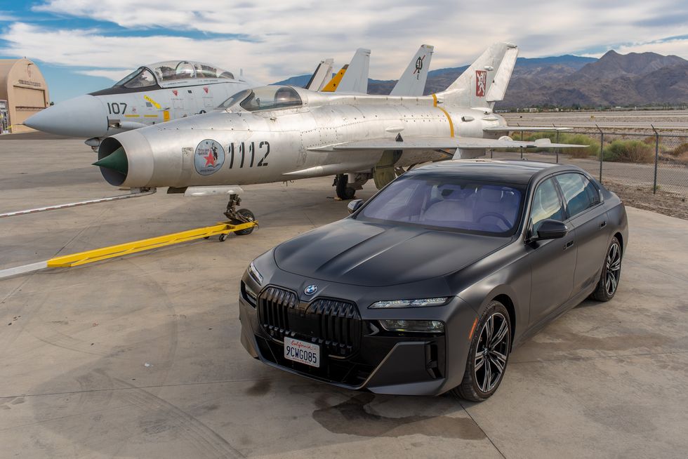 a car parked in front of a group of jets