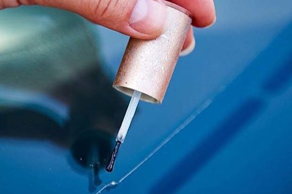 nail polish being used to recolor a scratch on a vehicle