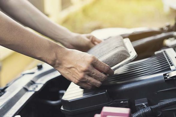 an air filter being replaced under the hood of a car