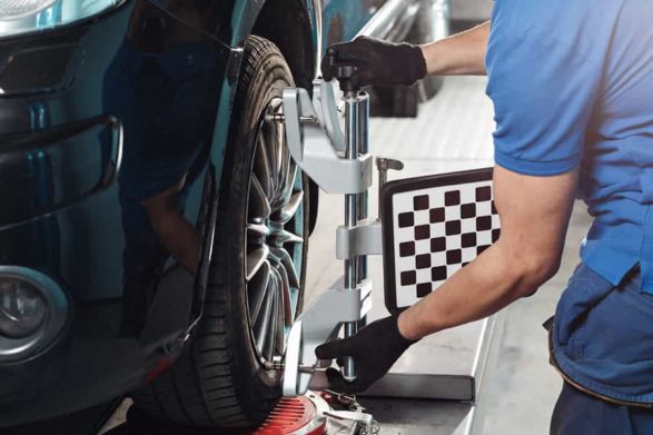 a mechanic fixing the alignment of a car tire