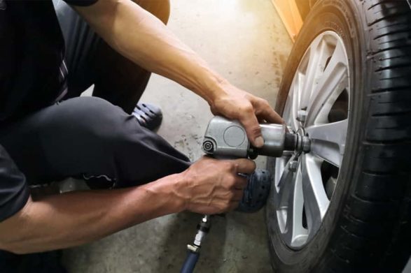 a mechanic readjucts the lug nuts of a car wheel